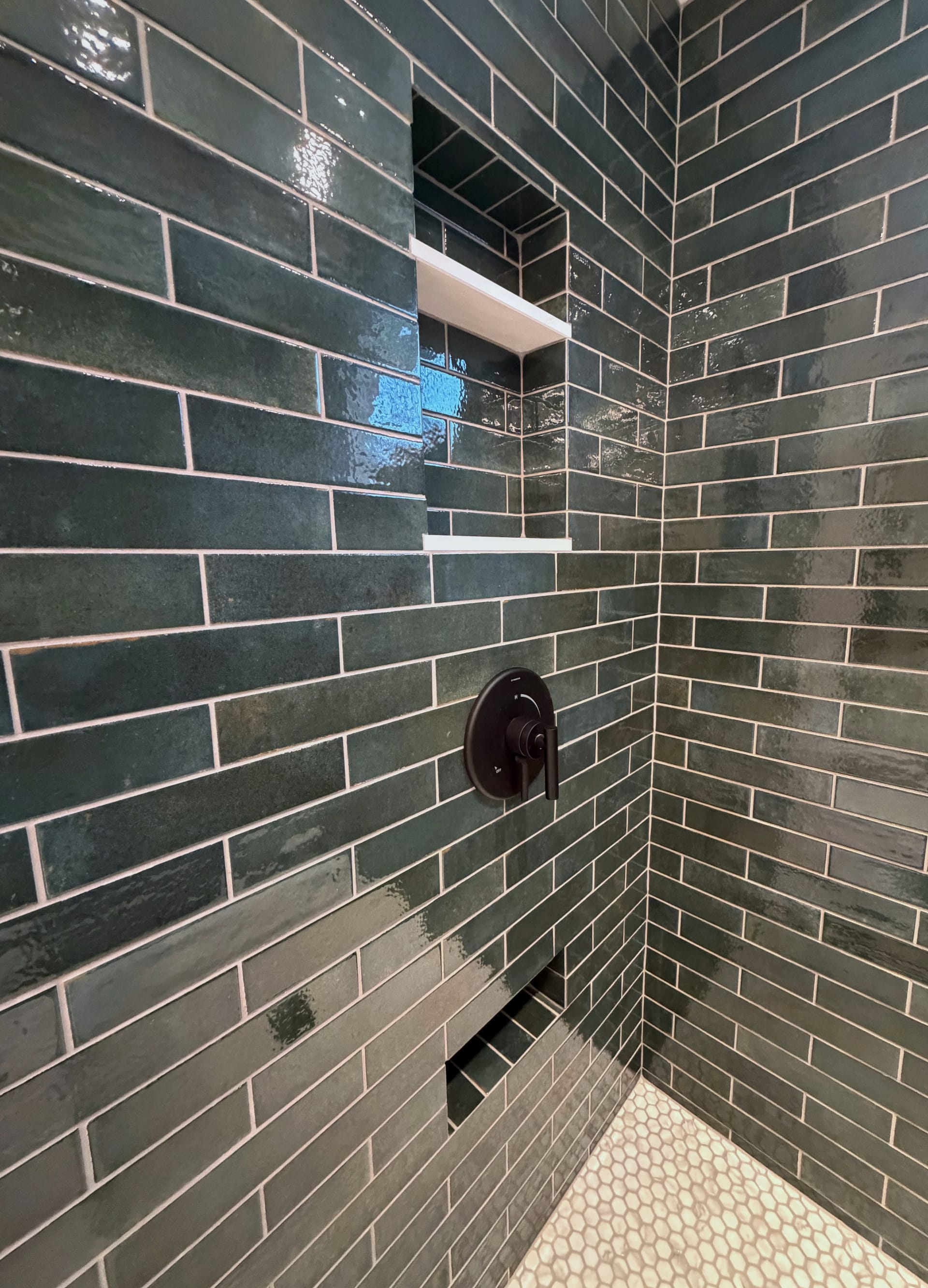 Elegant bathroom with glass shower, marble tiles and dark wood cabinets