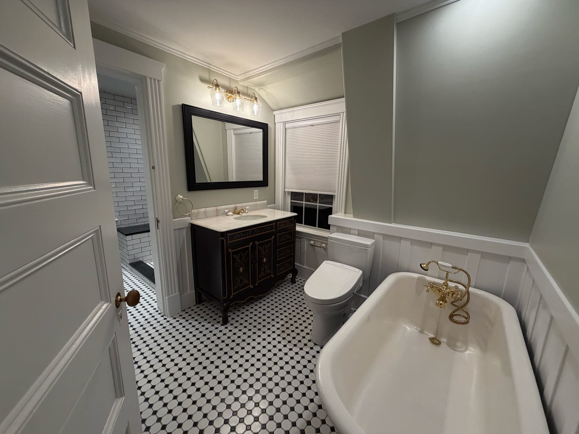 Elegant renovated bathroom with glass shower and freestanding tub