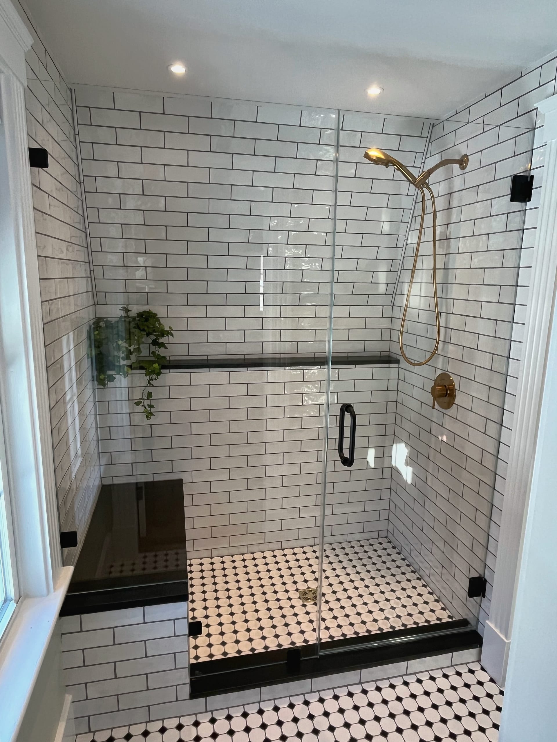 Modern bathroom with glass shower, stone walls and white vanity