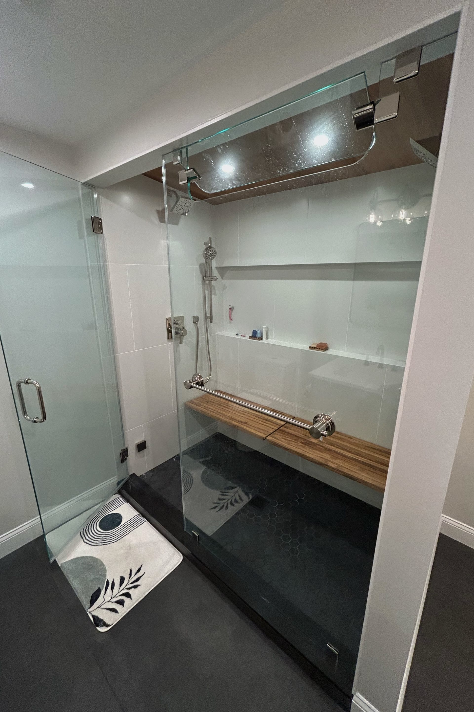 Bathroom shower with white subway tiles and black accent wall